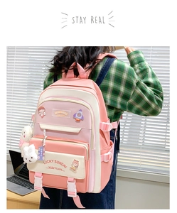 Detailed close-up of a pink and beige school backpack with cute plush rabbit charm