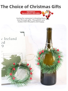 Close-up of mini Christmas wreath with green pine needles and red berries on wine bottle