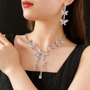 Détail de l'élégant ensemble collier et boucles d'oreilles papillon en argent