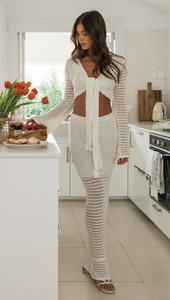 Dettaglio del completo a due pezzi in maglia bianca con top a V e gonna lunga ricamata