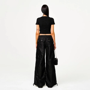 Back view of slim-fit black short sleeve tee and cargo pants on a model in street style