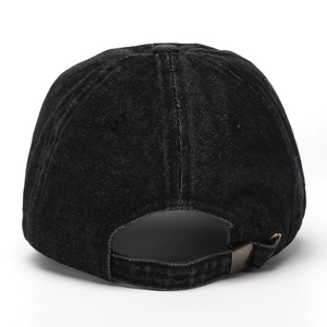 Detail view of the washed denim baseball cap featuring an adjustable metal buckle strap