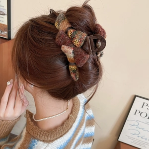Detail of large acrylic flocking bow hair claw showing knitted texture on model