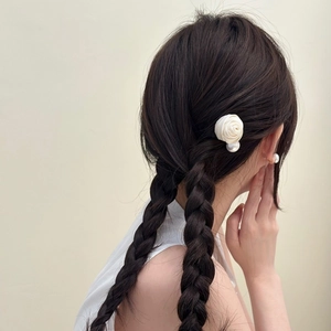 Barrette à cheveux rose en soie blanche et perle sur une coiffure tressée