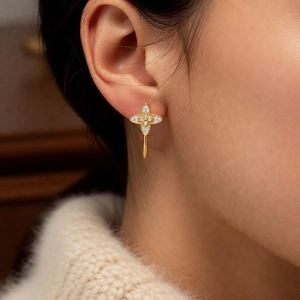Close-up of vintage C-shape clover stud earrings with pavé stones on a model
