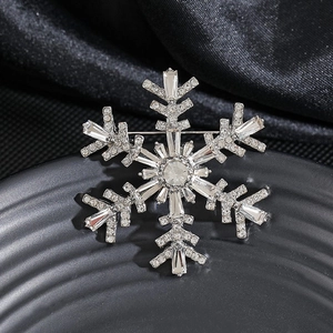 Elegant snowflake pearl brooch with shimmering rhinestones on a black velvet stand