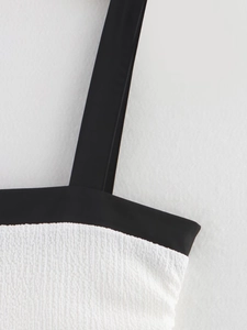 Macro detail of wide black shoulder straps and white textured bubble fabric stitching