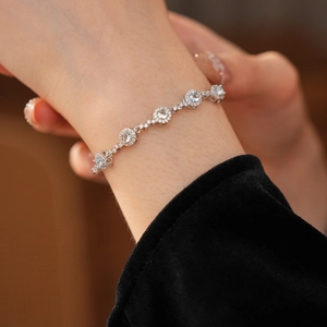 Détail de bracelet argenté avec pendentif en zircon bleu scintillant sur poignet et velours