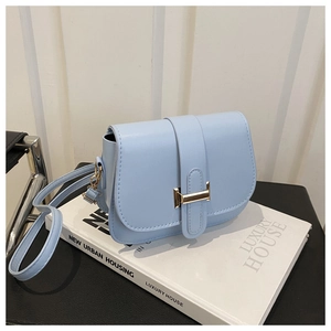 Detail of light blue square crossbody bag with gold metal buckle and smooth PU leather