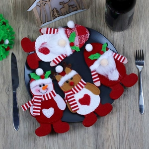 Detail of Christmas Santa Snowman Reindeer cutlery holders on a festive dinner plate