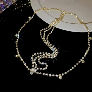 Gros plan d'une chaîne de tête dorée multicouche de luxe avec pendentifs en cristal brillant