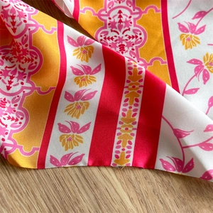 Macro detail of French bow hair tie showing vintage floral patterns on silky fabric