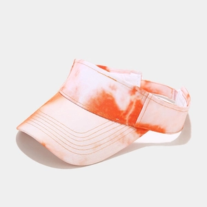 Detailed view of tie-dye visor hat showing orange and white patterns and stitching