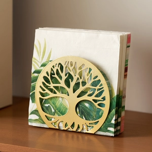 Golden metal napkin holder with tree of life design for bar and cafe tabletop decor