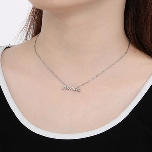 Detail showing a silver Mama script pendant with a sparkling diamond on a model neck
