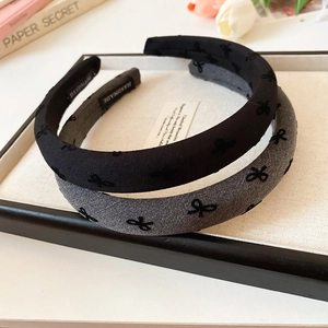 Detail view of wide bow headbands in black and grey with premium flocked texture fabric