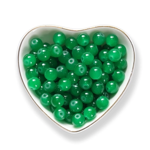 Perline di vetro verdi da 8mm per gioielli fai-da-te in una ciotola a cuore bianca