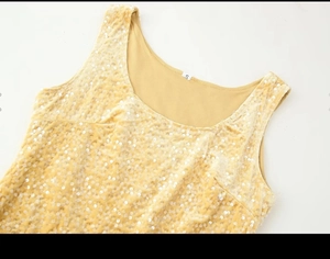 Detailed close-up of yellow sequin sleeveless top with size S label on soft velvet