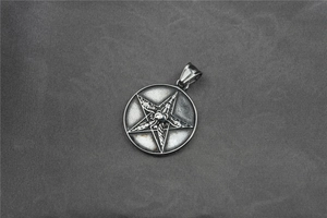 Macro detail of vintage silver stainless steel star pendant with central skull carving
