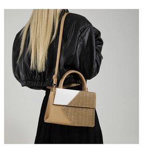 Minimalist khaki and white geometric shoulder bag styled with a black leather jacket