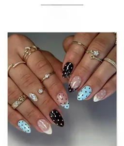 Detail of almond-shaped press-on nails with blue and black polka dots and French tip design