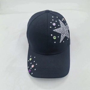 Detail of silver sequin star and purple rhinestones on a black cotton baseball cap