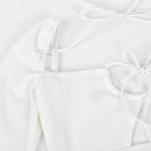 Close-up of white waffle knit fabric with lace-up tie detail on a sexy mini dress