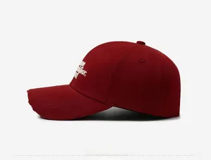 Close-up of vintage distressed burgundy baseball cap with white side embroidery detail