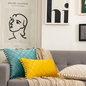 Diamond quilted velvet throw pillows with pom-pom fringe in teal, yellow and cream