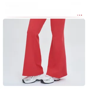 Vue détaillée de la coupe évasée et du tissu en maille rouge du pantalon de sport