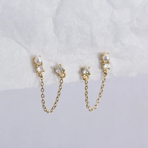 Detail of 925 silver earrings with pearls and zircon tassels on white background