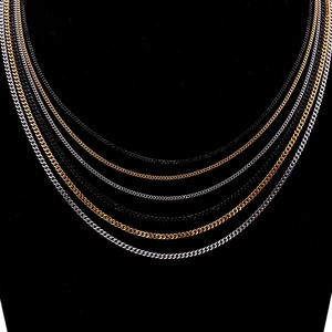 Flat lay of Cuban link chains in gold, silver and black finishes with metallic texture