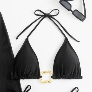 Close-up of black triangle bikini top featuring a gold heart-shaped metal ring connector