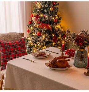 Detail shot of beige linen tablecloth set for Christmas dinner with warm festive lighting