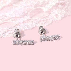 Minimalist silver rectangle bar stud earrings with sparkling cubic zirconia on lace backdrop