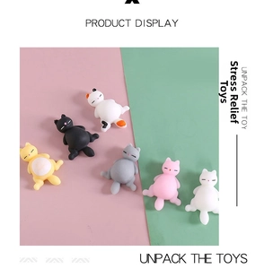 Set of six colorful cat squishy stress relief toys on a split pastel pink and green background