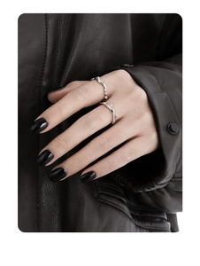 Macro shot of silver irregular vine rings with zircon micro-inlay on a female model