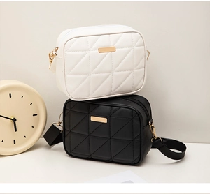 Close-up of quilted diamond pattern bags in black and white with gold metal hardware