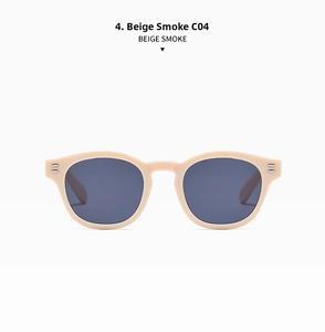 Detailed close-up of beige round sunglass frame with silver rivets and smoke gray lenses