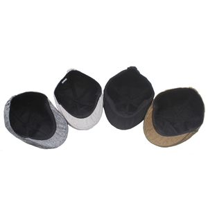 Detail view of cotton linen flat caps in grey, black and brown with textured weave
