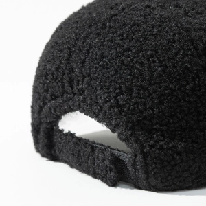 Detail of adjustable metal buckle and black teddy fleece texture on the baseball cap