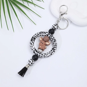 Detail of cartoon elk silicone keychain with black and white spotted beads and a black tassel