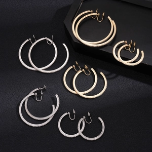 Set of gold and silver rhinestone hoop ear clips in various sizes on black display