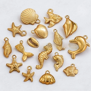 Detailed close-up of gold stainless steel marine charms including seahorse and starfish