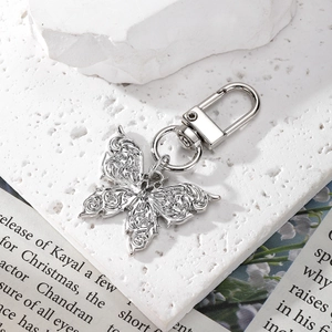 Detailed view of silver crystal butterfly keychain with rhinestones on a textured background