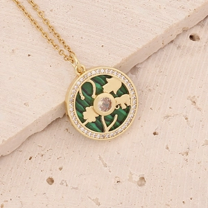 Macro detail of 18K gold necklace with green malachite clover pendant and central diamond