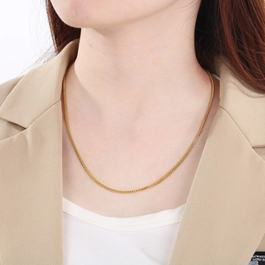 Close-up of a stylish gold dragon scale chain necklace worn on a model's neck