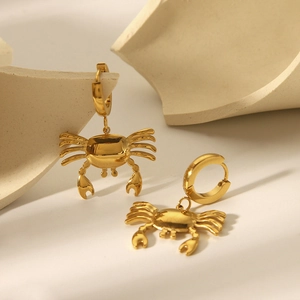 Elegant 18k gold plated stainless steel crab drop earrings on a ceramic background