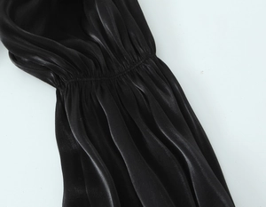 Gros plan sur l'élégant tissu en satin noir avec des détails plissés et un drapé fluide