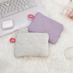 Close-up of quilted storage pouches in lavender and cream on a soft plush surface